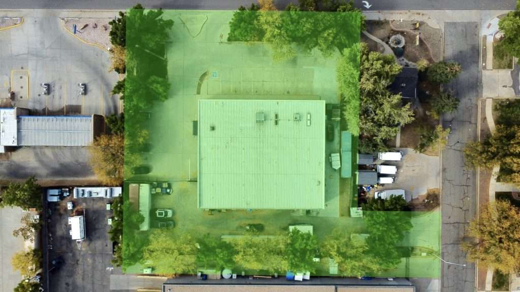 Aerial view of the industrial property at 5280 Ward Road in Arvada, Colorado, showing the top of the building and property highlighted a green color.